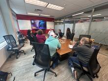 Group of teachers sitting in a conference room listening to a speaker