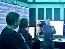 A group in a quatum laboratory listening to a teacher