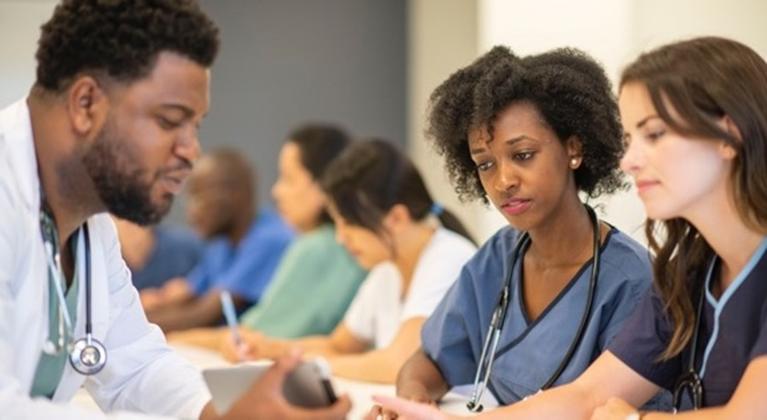 A group of direct care workers looking at a tablet
